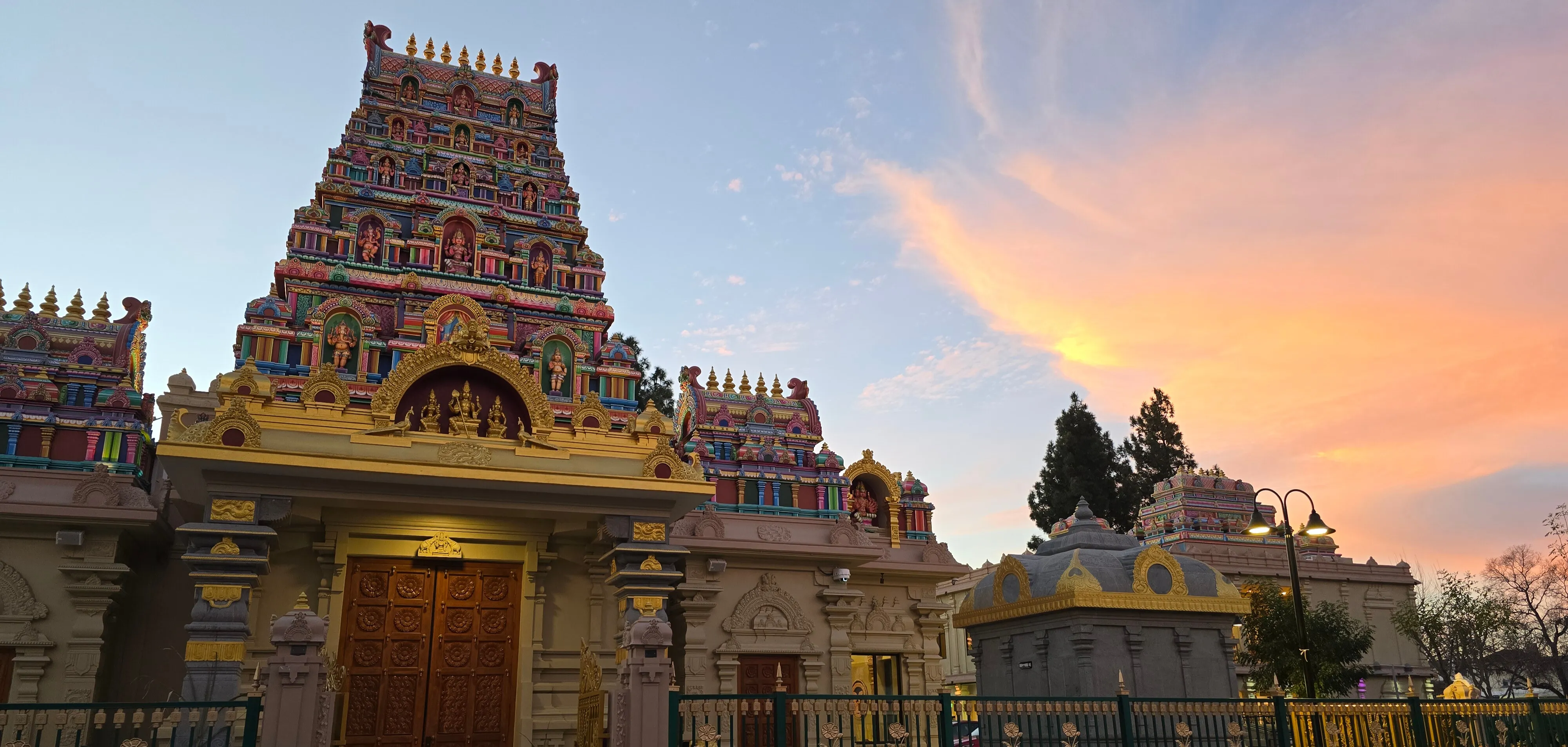 The colorful, intricate gopuram tower of the Concord Murugan Temple glowing under a soft pink and orange sunset sky - photo captured by me in January 2026.