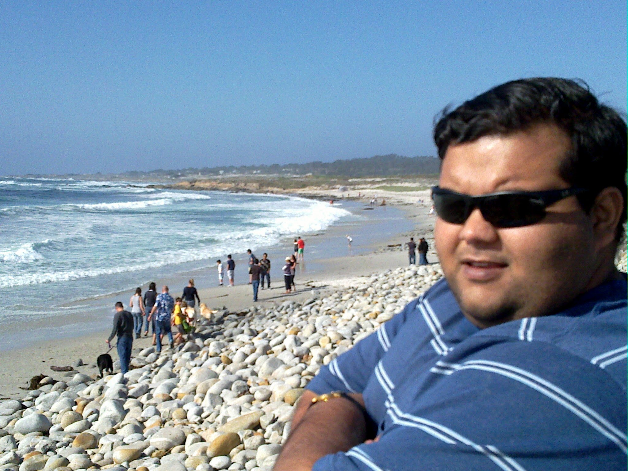 Me at Pebble Beach in 2010 as a grad student, sitting on the rocky shoreline with waves in the background